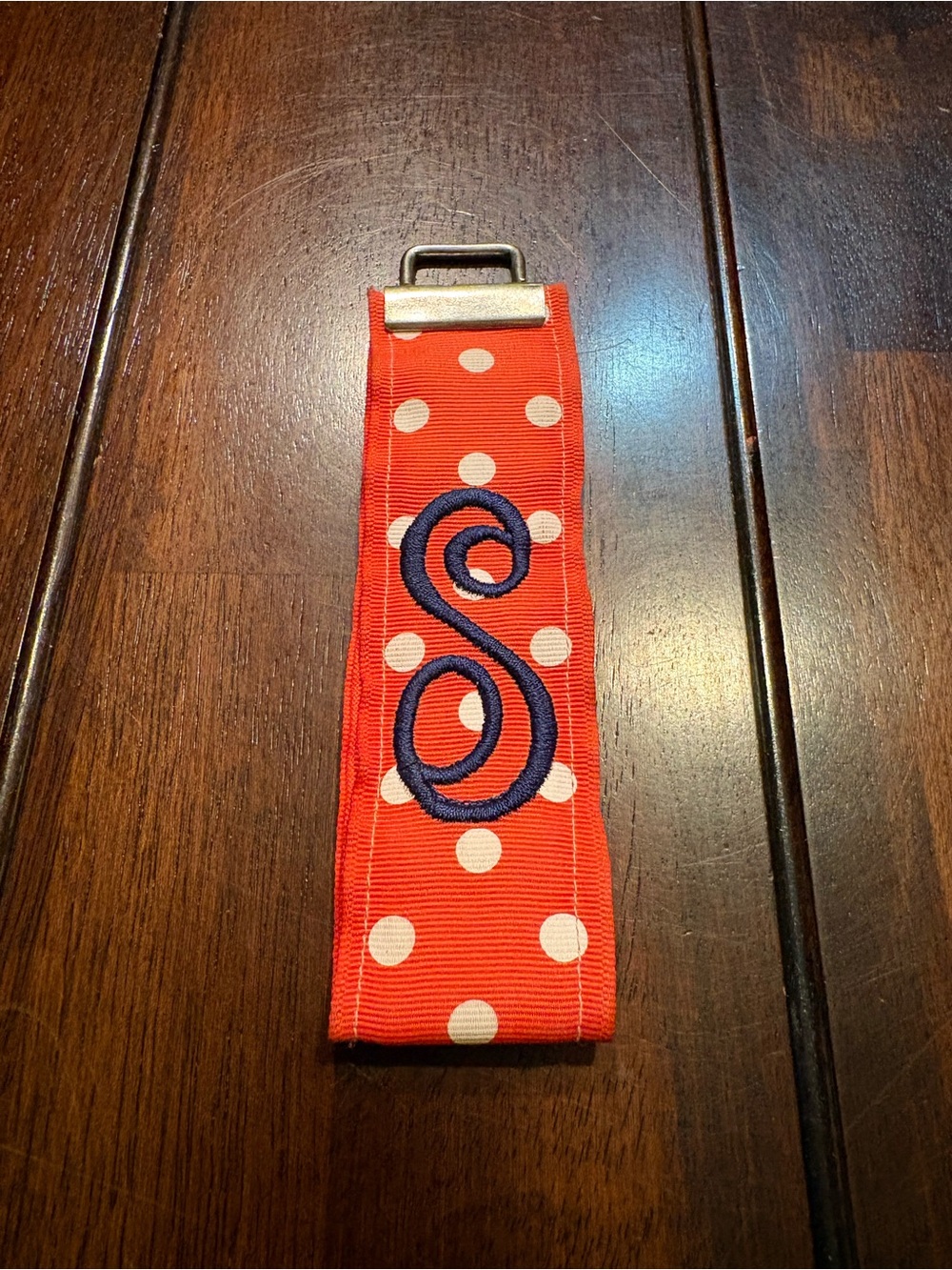 Orange polka dot keychain with navy blue “S”monogram